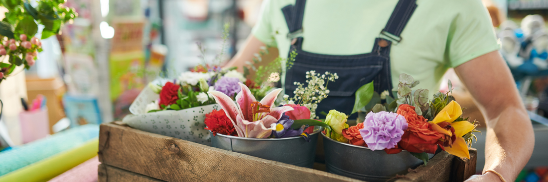 man holding box of three flower arrangements
