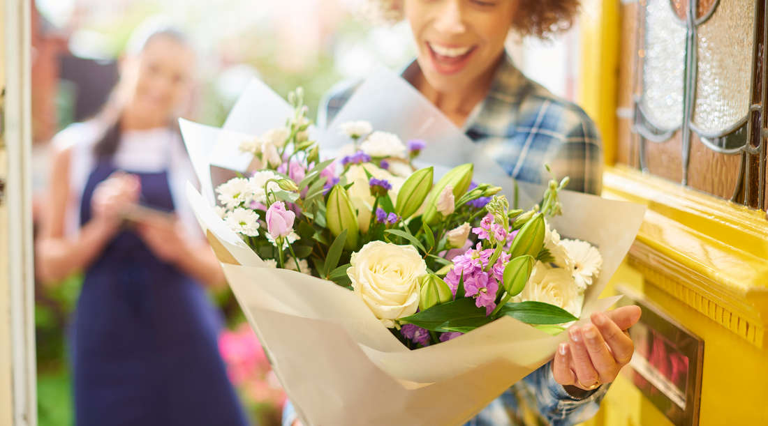 Image of happy customer in plaid shirt receiving a beautiful bouquet of pastel flowers for flower delivery Brisbane 