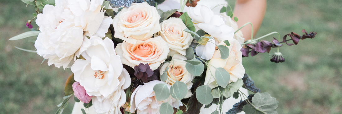 close up image of wedding bouquet by brisbane florist with soft pink and white blooms including roses and dahlias and muted greens