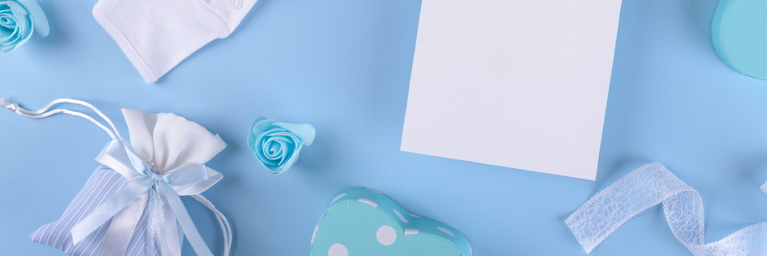 image of a blue background with small gift bags, white paper, polka dot paper and ribbons for flowers and gifts for baby boy