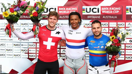 three male BMX World Champions on the podium holding The Flower Farm podium flower arrangements