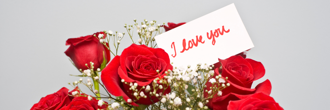 bouquet of red roses and white babies breath with a tag that reads I love you for Valentine's Day flowers